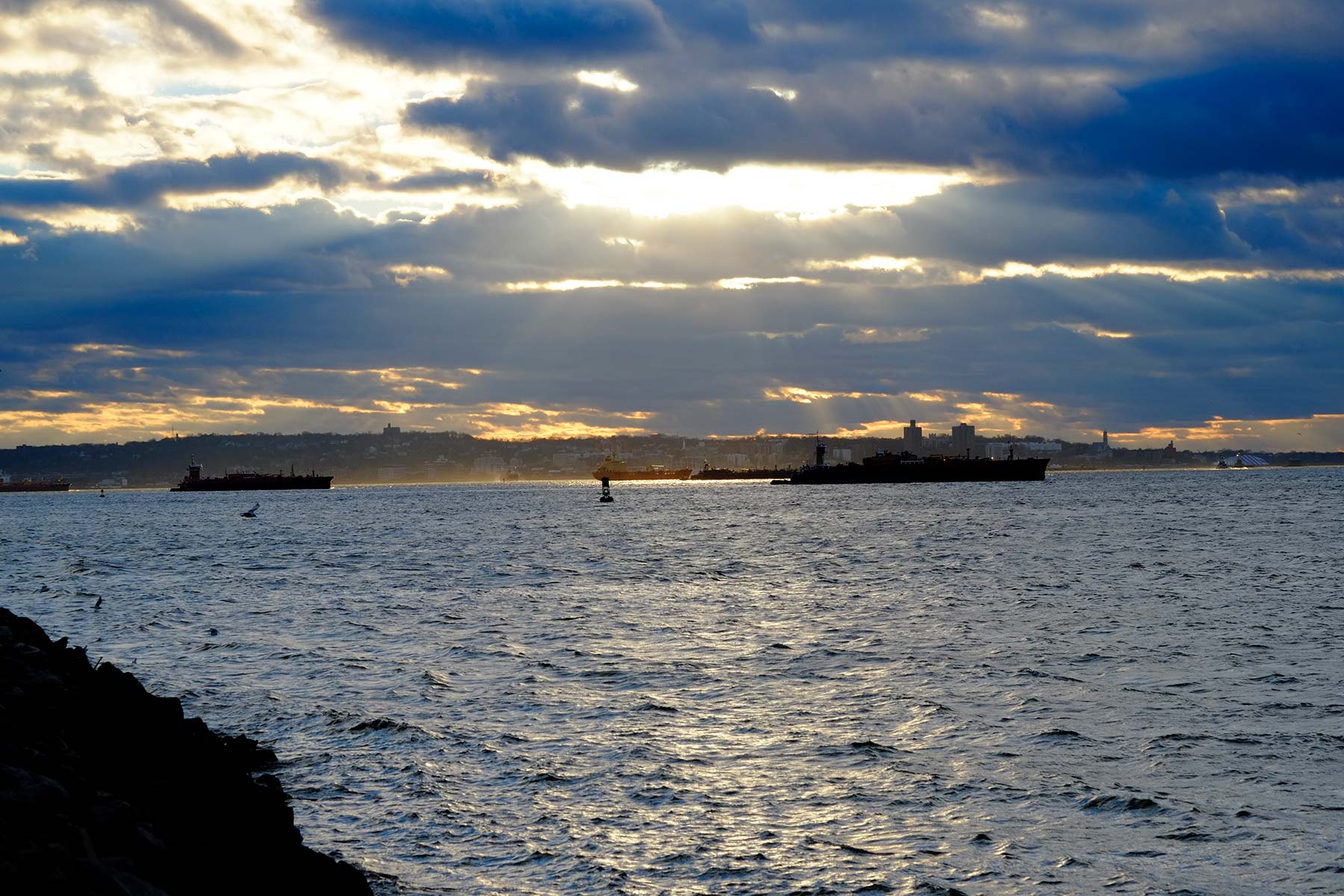 NY Harbor with blast of a sunbeam at dusk.