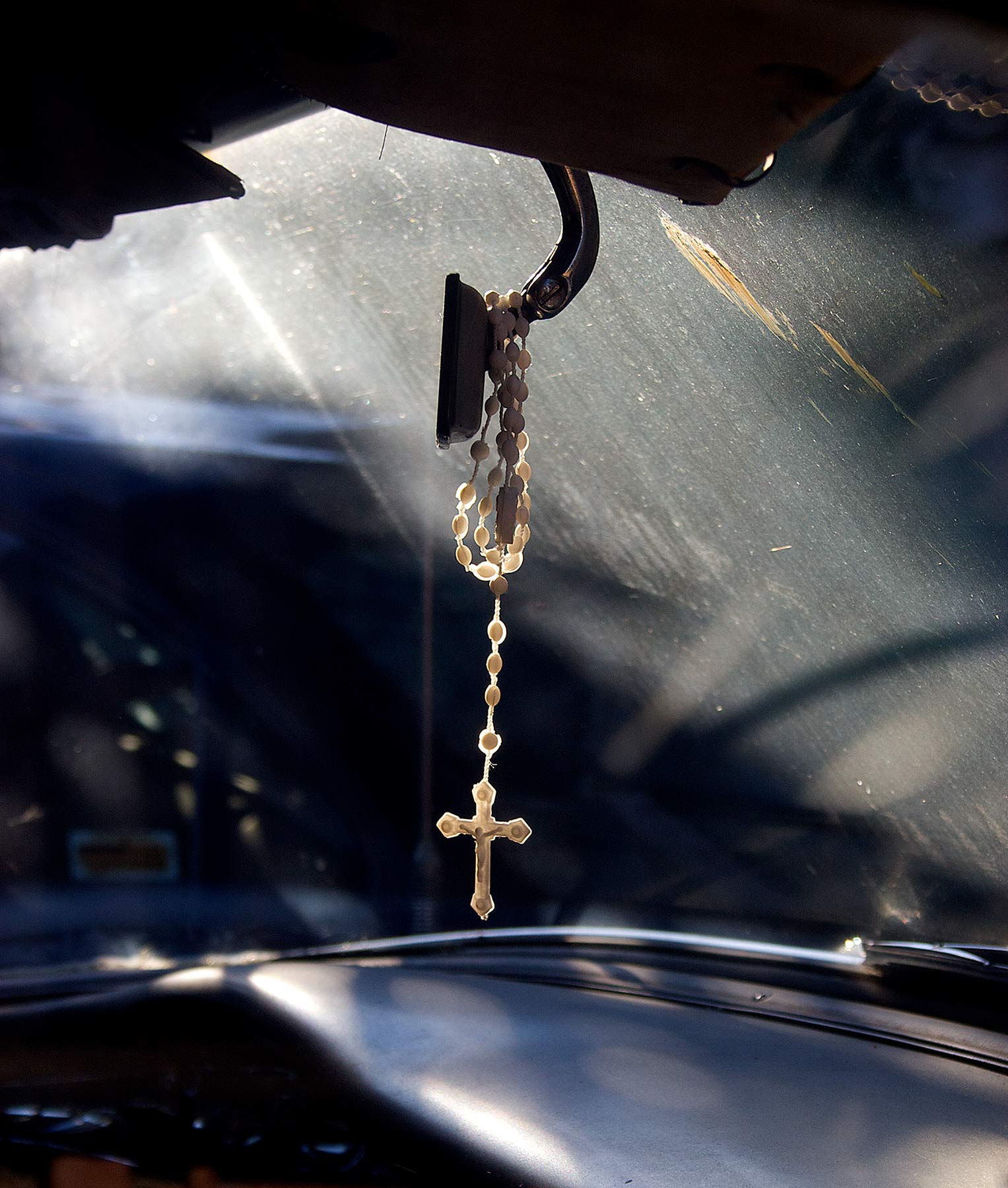 Old Cross hanging from Rearview Mirror in an Old Chevy Car
