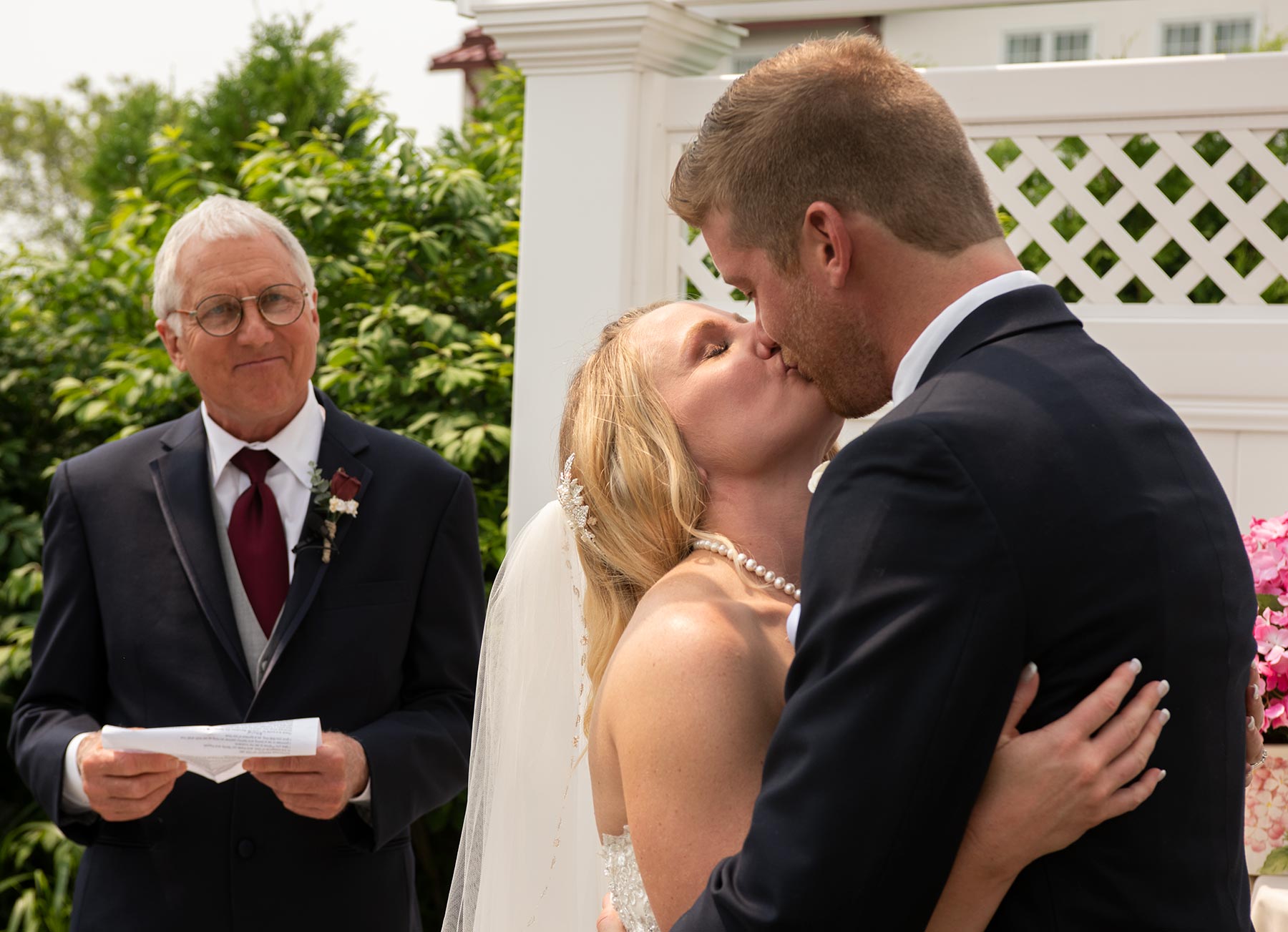 Summer-Bride-kissing-groom-at-ceremony