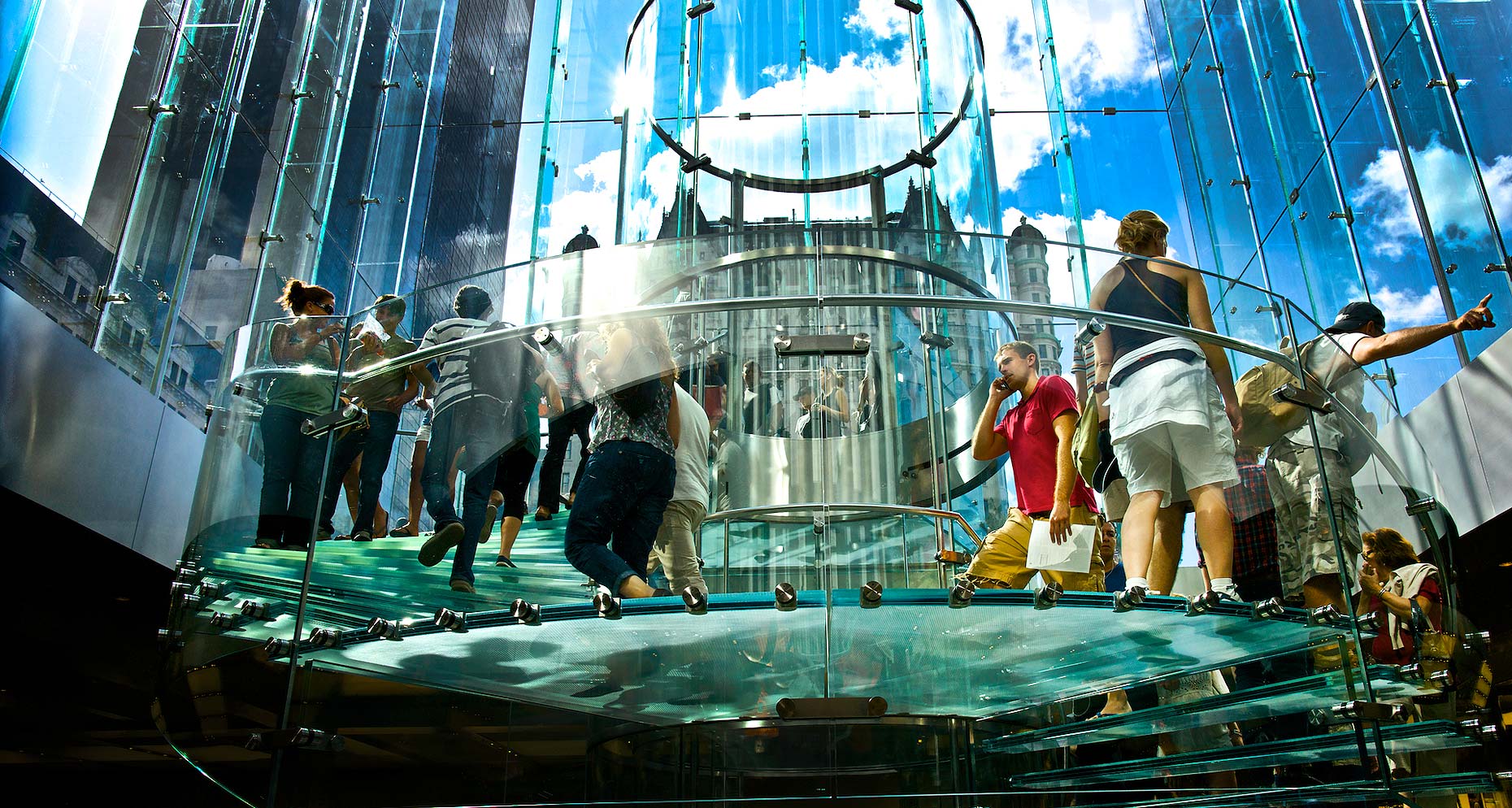 Glass stairwell of Apple Store on 5th ave NYC with customers. 